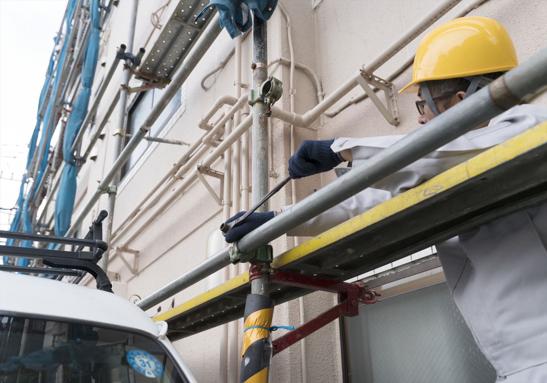 足場のボルトを締めるスタッフ